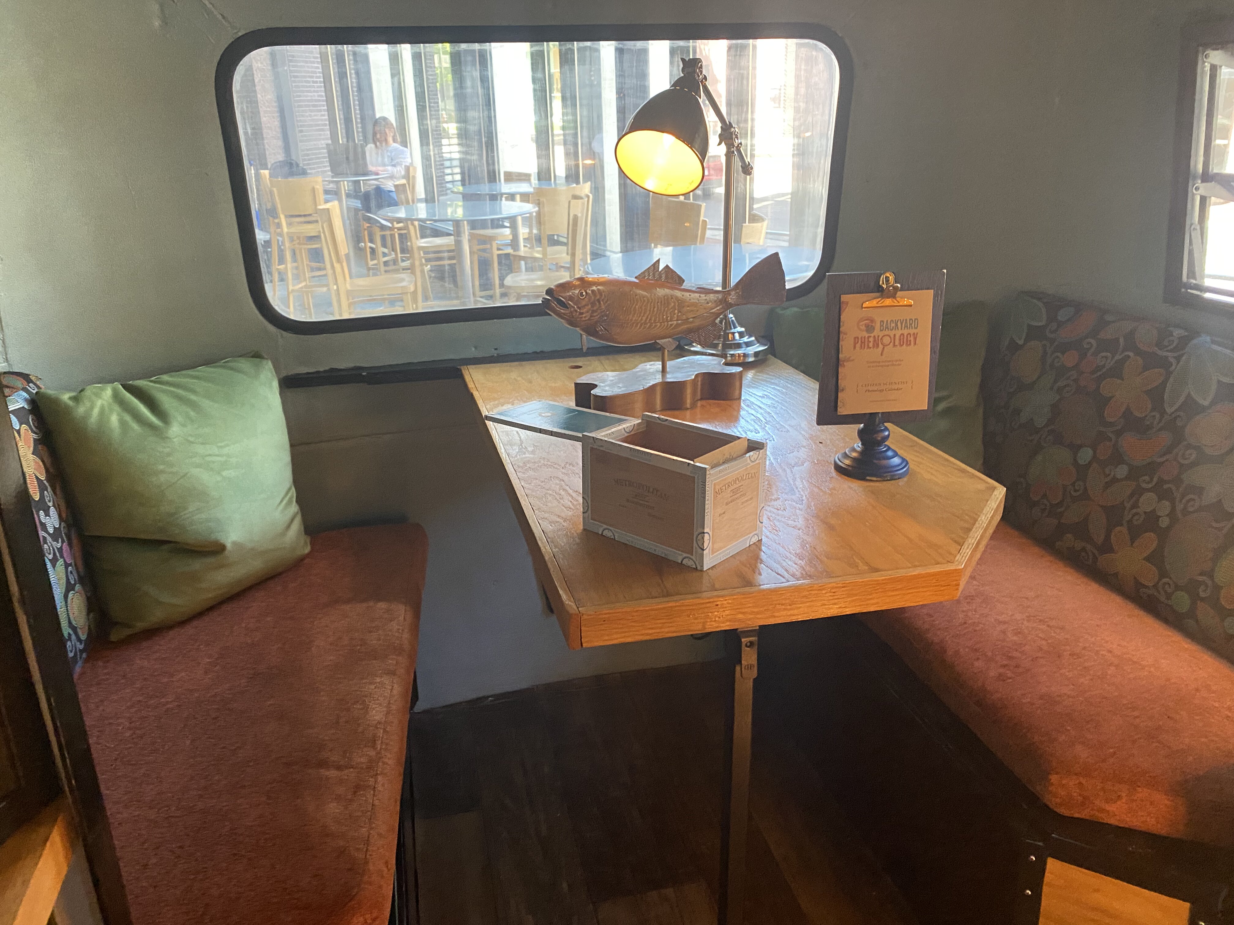 Camper interiorwith cushioned seating around a table and objects to interact with