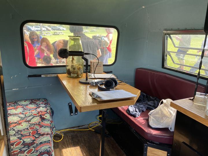 View from inside the Climate Chaser camper, looking out the window at people gathered